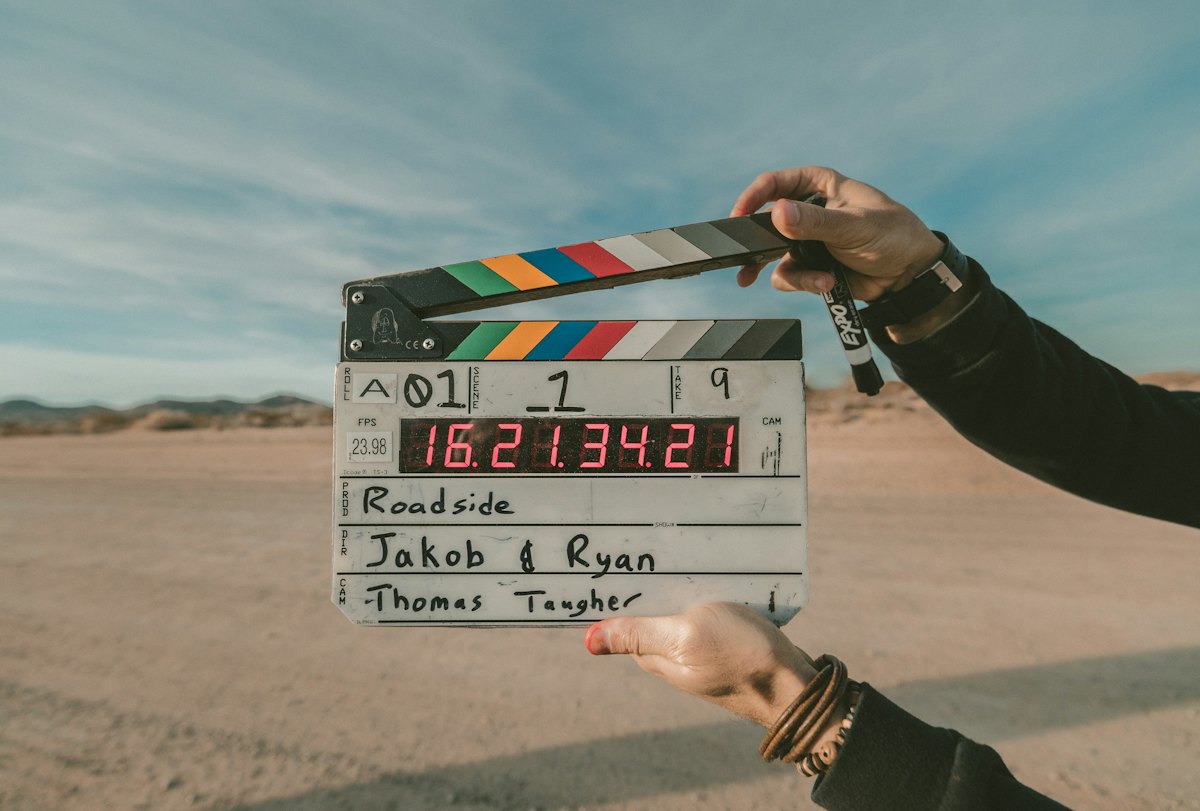 A film clapperboard held up against a clear sky